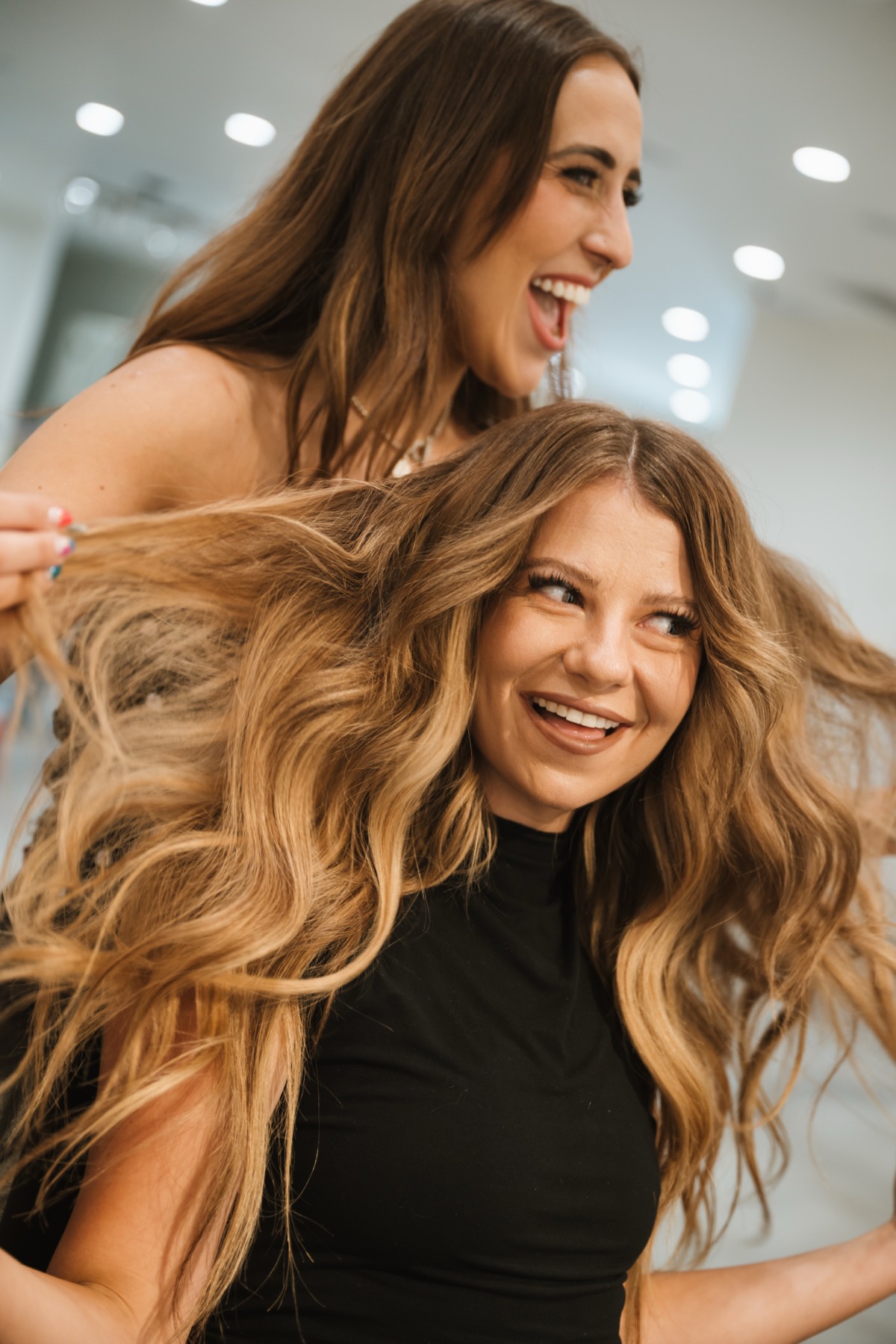 Two beauty professionals smiling in a salon